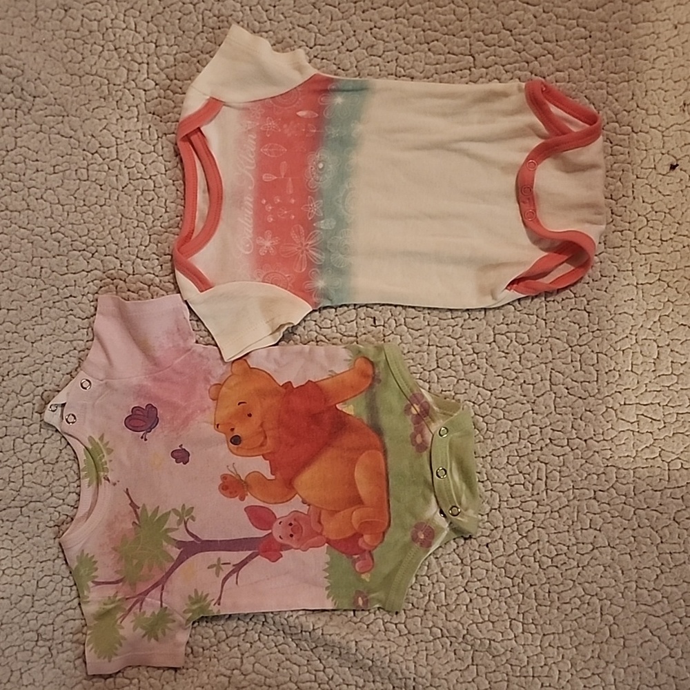 Baby onsies. One is Winnie the Pooh.